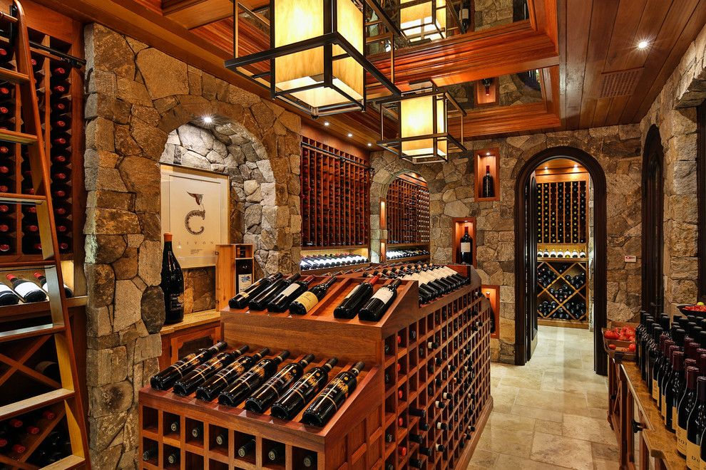 This is an example of a mid-sized traditional wine cellar in New York with limestone floors, display racks and beige floor.