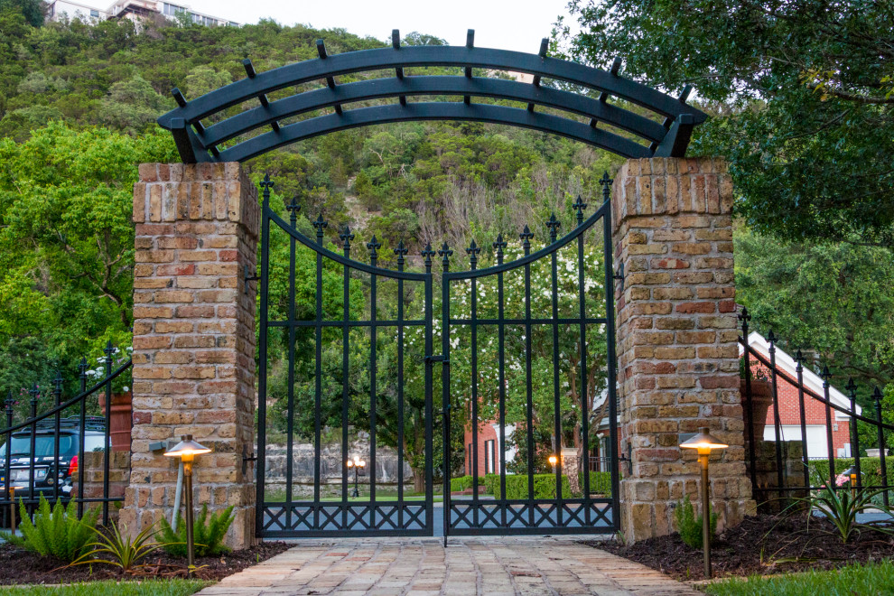 Großer, Halbschattiger Klassischer Garten im Sommer mit Pflastersteinen und Metallzaun in Austin
