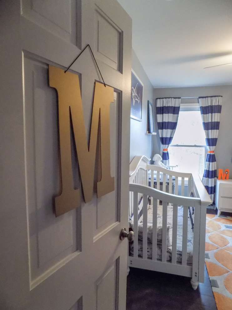 This is an example of a small modern nursery for boys in Detroit with grey walls, laminate floors and grey floor.