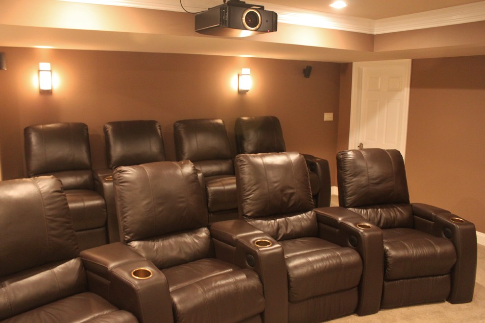 Photo of a mid-sized traditional enclosed home theatre in Philadelphia with brown walls, carpet, a projector screen and beige floor.