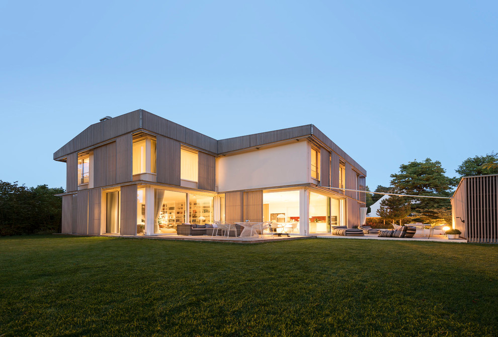 Großes, Zweistöckiges Modernes Haus mit brauner Fassadenfarbe und Satteldach in München