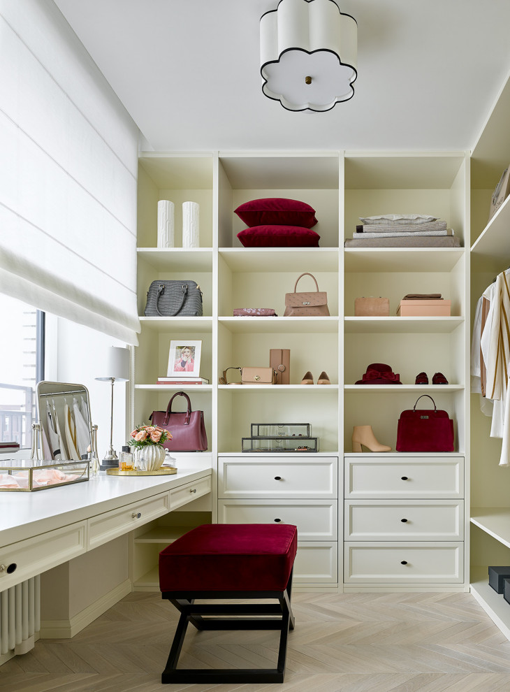 This is an example of a transitional women's dressing room in Moscow with open cabinets, white cabinets, light hardwood floors and beige floor.