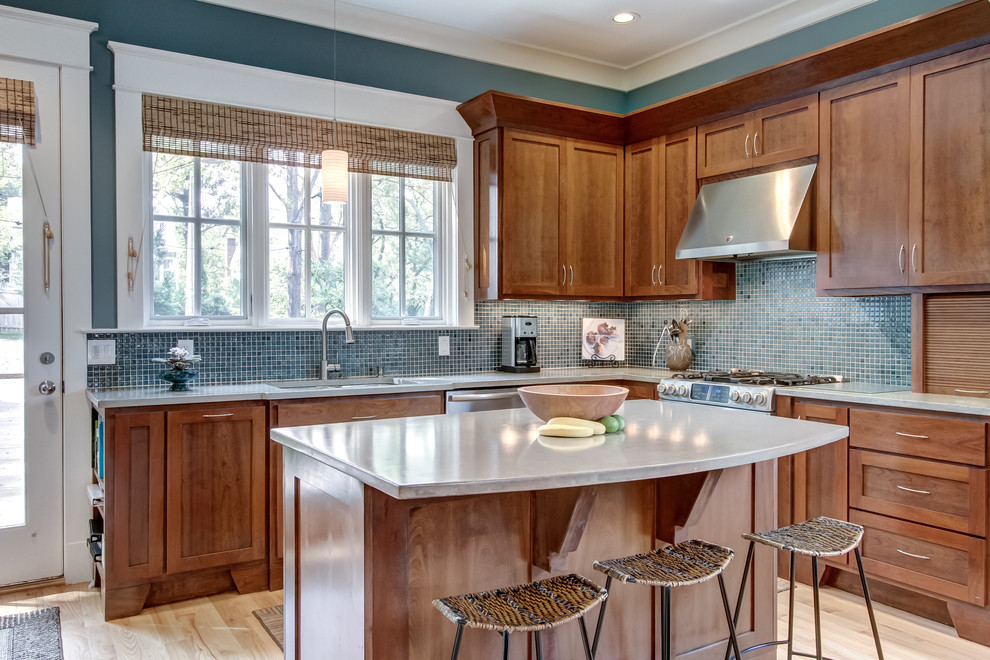 Photo of a contemporary l-shaped open plan kitchen in Nashville with concrete benchtops, stainless steel appliances, shaker cabinets, medium wood cabinets, blue splashback, mosaic tile splashback, light hardwood floors and with island.