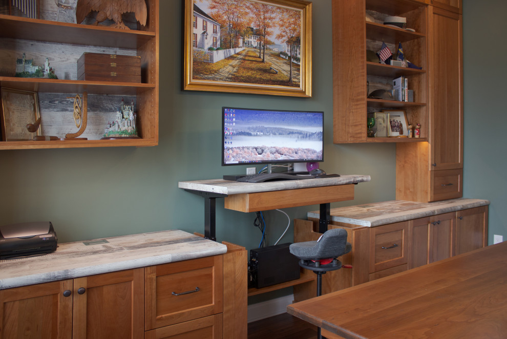 Mid-sized elegant built-in desk medium tone wood floor and brown floor home office photo in New York with green walls