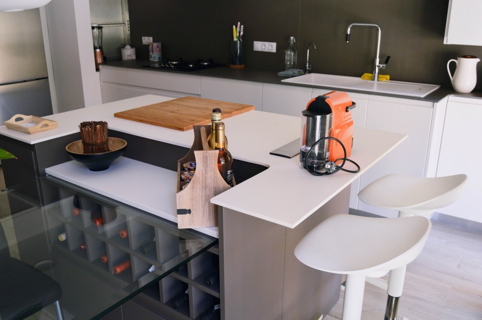 This is an example of a mid-sized contemporary single-wall eat-in kitchen in Barcelona with a single-bowl sink, flat-panel cabinets, white cabinets, brown splashback, stainless steel appliances, ceramic floors, with island, brown floor and brown benchtop.