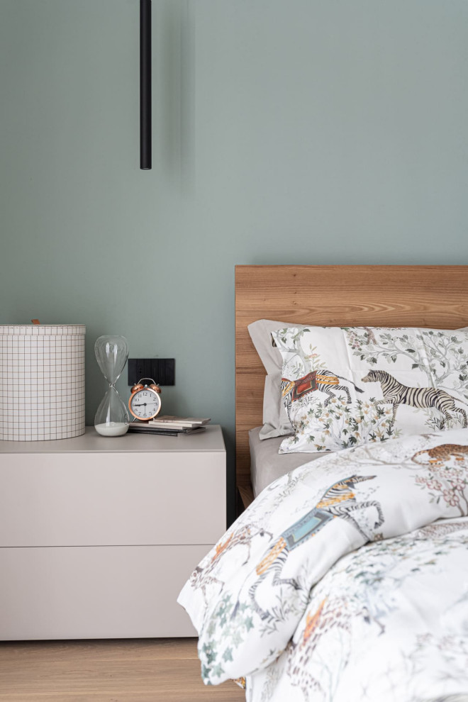 Scandi master bedroom in Other with green walls and dark hardwood flooring.