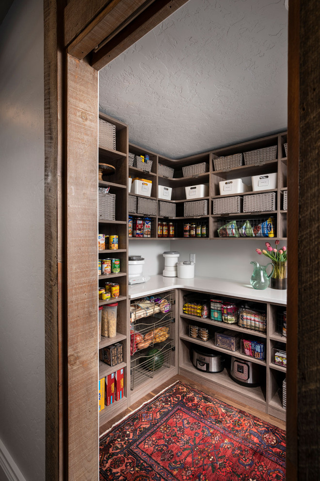 This is an example of a mid-sized transitional u-shaped kitchen pantry in Other with open cabinets, medium wood cabinets, medium hardwood floors, brown floor and white benchtop.