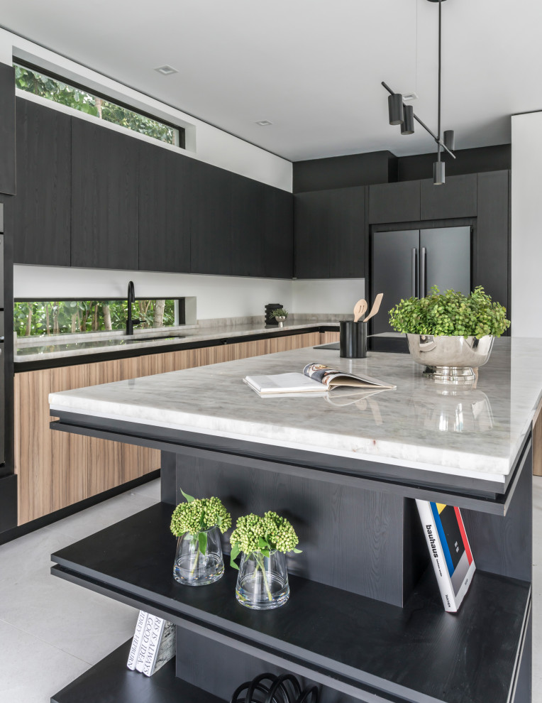 Inspiration for a mid-sized contemporary u-shaped eat-in kitchen in Miami with a single-bowl sink, flat-panel cabinets, black cabinets, onyx benchtops, beige splashback, marble splashback, black appliances, ceramic floors, with island, grey floor and beige benchtop.