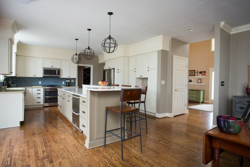 Huge transitional u-shaped dark wood floor open concept kitchen photo with an undermount sink, shaker cabinets, gray cabinets, quartz countertops, blue backsplash, glass tile backsplash, stainless steel appliances and an island