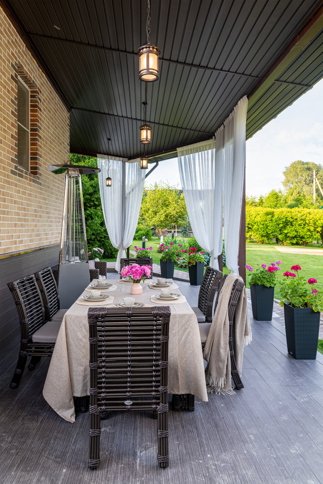 Modelo de terraza planta baja mediterránea de tamaño medio en patio trasero y anexo de casas con cocina exterior y barandilla de varios materiales