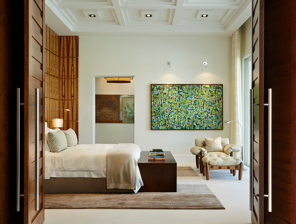 This is an example of a contemporary master bedroom in Miami with white walls and limestone floors.