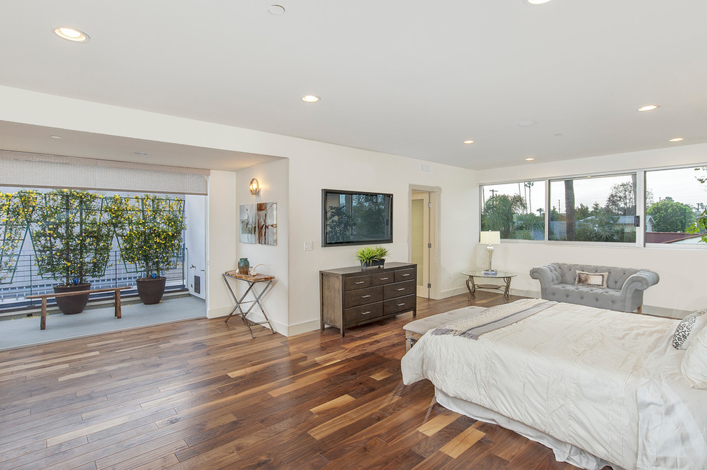 This is an example of a large modern master bedroom in Los Angeles with grey walls and medium hardwood floors.