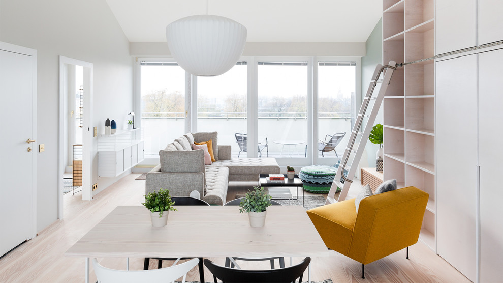 Mid-sized scandinavian formal open concept living room in Other with white walls, light hardwood floors, no fireplace, a wall-mounted tv and beige floor.