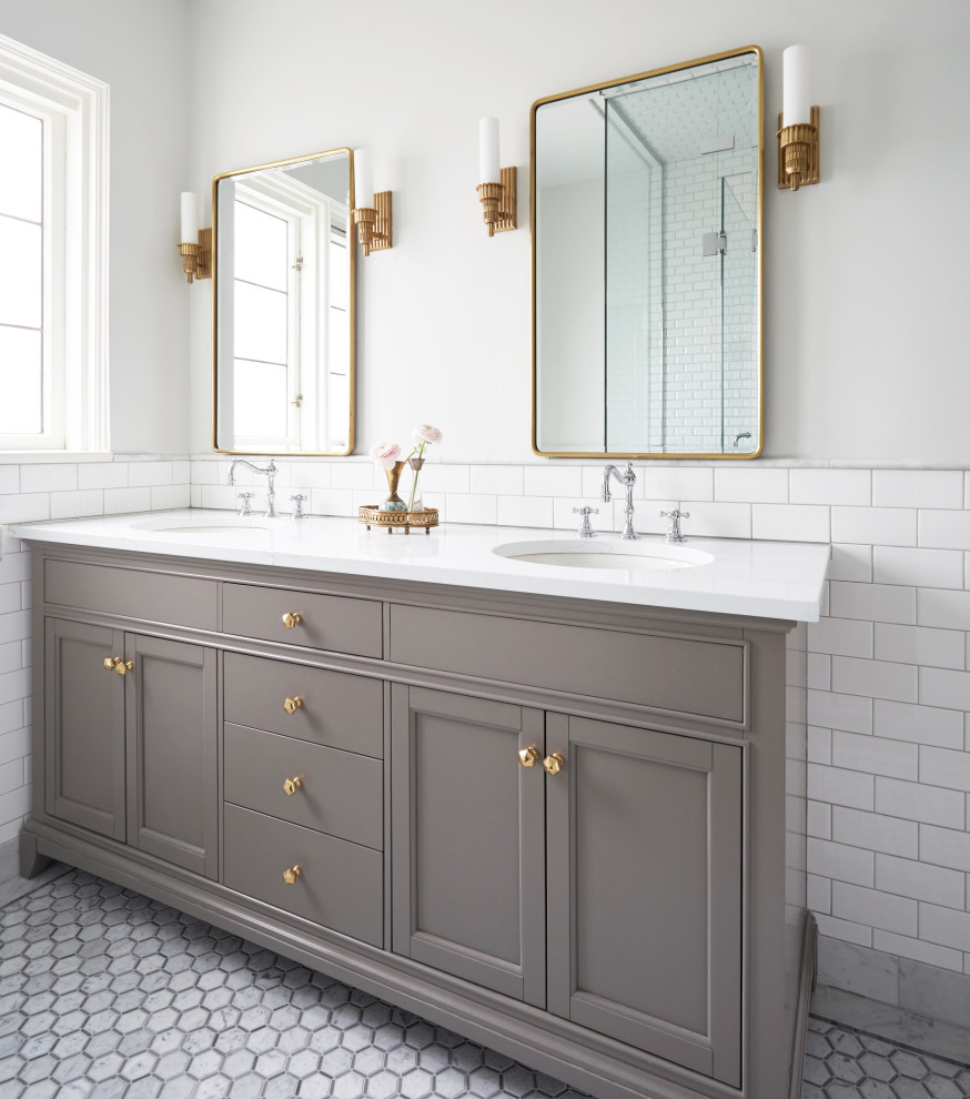 This is an example of a transitional bathroom in Chicago with grey cabinets, white tile, subway tile, grey walls, marble floors, white floor, white benchtops and a double vanity.