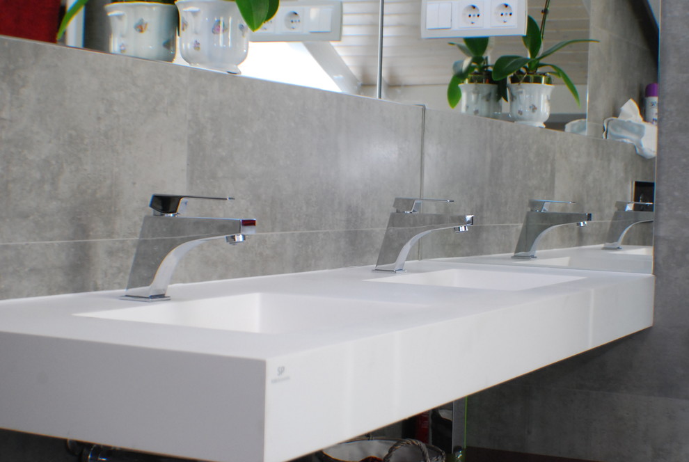 Modelo de cuarto de baño moderno con sanitario de pared, lavabo suspendido y encimera de acrílico