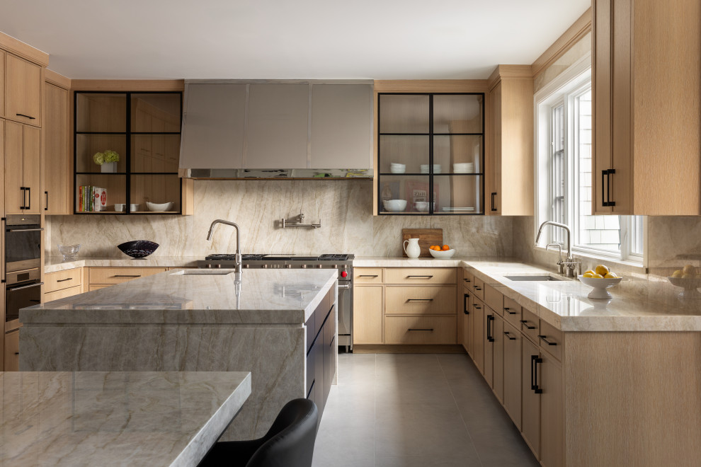 Example of a mid-sized transitional u-shaped beige floor enclosed kitchen design in New York with an undermount sink, recessed-panel cabinets, light wood cabinets, granite countertops, beige backsplash, granite backsplash, stainless steel appliances, beige countertops and two islands