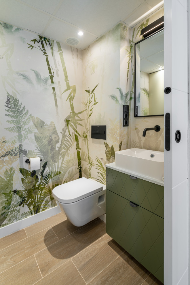 Kleine Moderne Gästetoilette mit profilierten Schrankfronten, grünen Schränken, Laminat-Waschtisch, schwebendem Waschtisch und Tapetenwänden in Sonstige