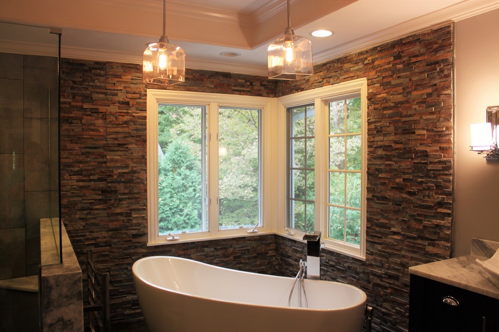 Photo of a mid-sized transitional master bathroom in Indianapolis with furniture-like cabinets, dark wood cabinets, a freestanding tub, a double shower, a bidet, multi-coloured tile, stone tile, grey walls, slate floors, a vessel sink and marble benchtops.