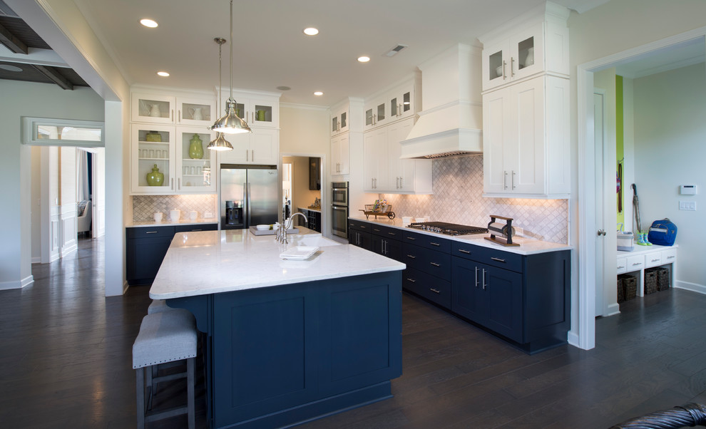 This is an example of a mid-sized transitional l-shaped open plan kitchen in Charleston with a farmhouse sink, shaker cabinets, blue cabinets, marble benchtops, grey splashback, marble splashback, stainless steel appliances, dark hardwood floors and with island.