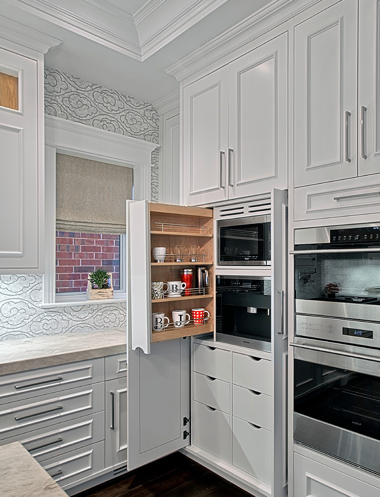 Design ideas for a large transitional kitchen in Chicago with white cabinets, stainless steel appliances, dark hardwood floors, recessed-panel cabinets, quartzite benchtops, white splashback, mosaic tile splashback, brown floor and beige benchtop.