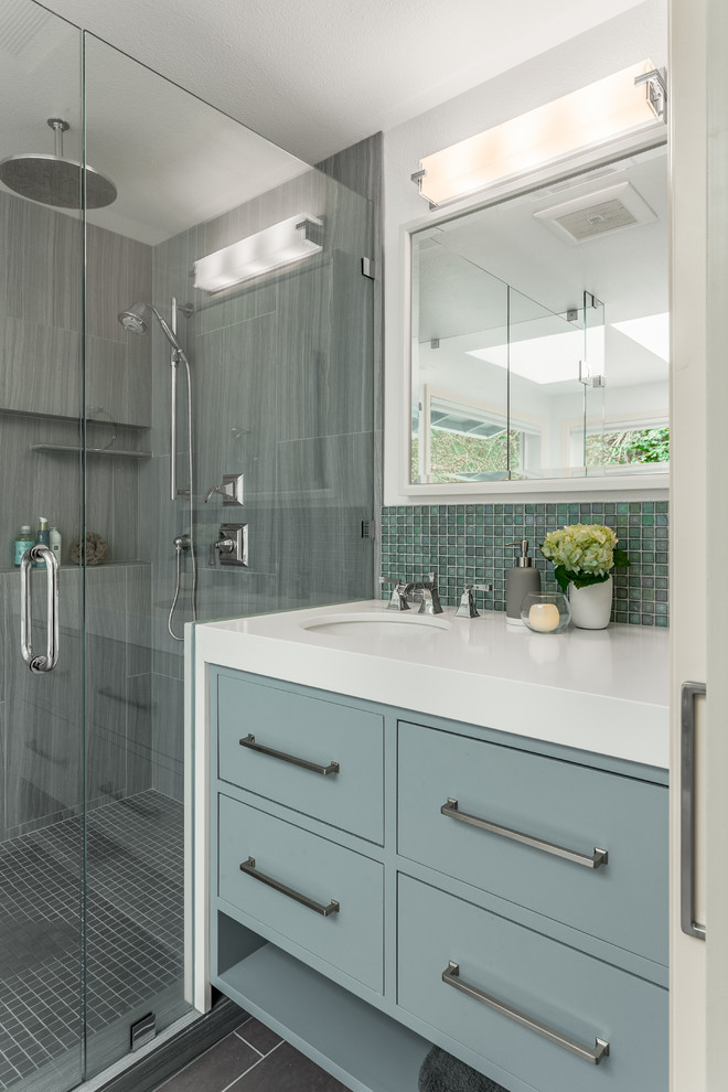 Photo of a transitional master bathroom in Seattle with flat-panel cabinets, grey cabinets, a freestanding tub, a double shower, a one-piece toilet, gray tile, glass tile, white walls, porcelain floors, an undermount sink and engineered quartz benchtops.