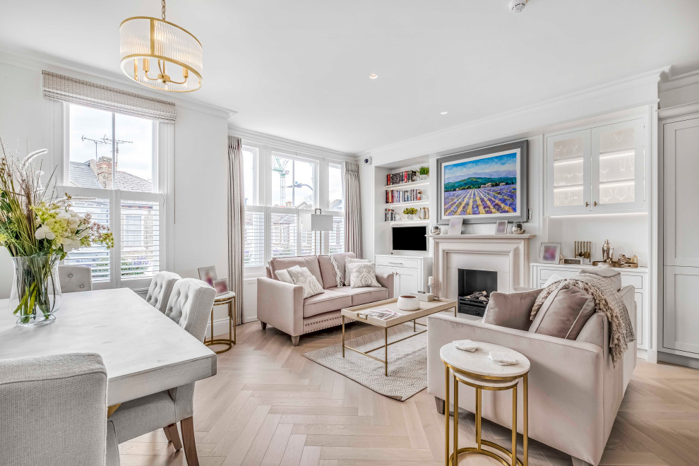 This is an example of a large classic formal open plan living room in London with white walls, light hardwood flooring, a standard fireplace, a stone fireplace surround and brown floors.