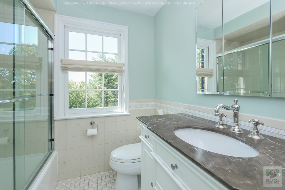 Exemple d'une salle de bain de taille moyenne avec des portes de placard blanches, une baignoire en alcôve, un combiné douche/baignoire, WC à poser, un carrelage beige, des carreaux de céramique, un mur vert, un sol en carrelage de céramique, un lavabo encastré, un plan de toilette en marbre, un sol multicolore, une cabine de douche à porte coulissante, un plan de toilette marron, meuble simple vasque et meuble-lavabo sur pied.