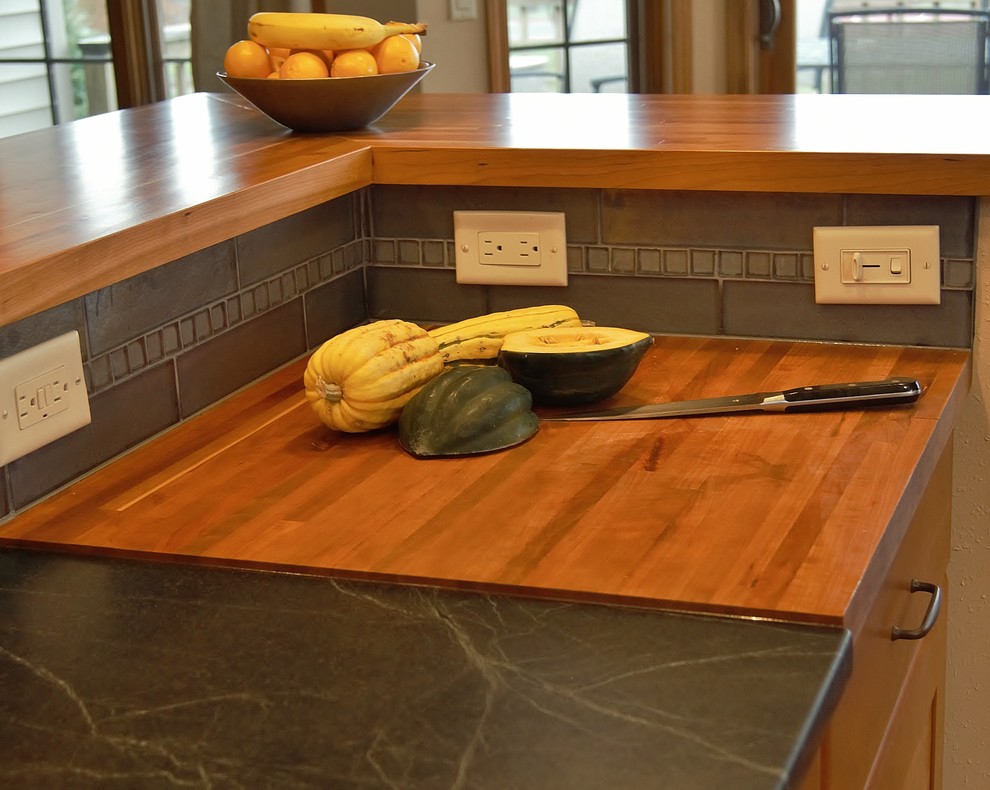 Transitional galley medium tone wood floor eat-in kitchen photo with a double-bowl sink, recessed-panel cabinets, medium tone wood cabinets, soapstone countertops, stainless steel appliances and an island
