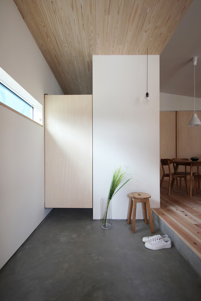 Idee per un corridoio con pareti marroni, una porta singola, una porta in legno scuro, pavimento grigio, soffitto in legno, pareti in perlinato e armadio