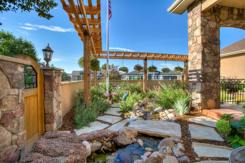 Inspiration for a mid-sized transitional partial sun front yard stone walkway in Denver.