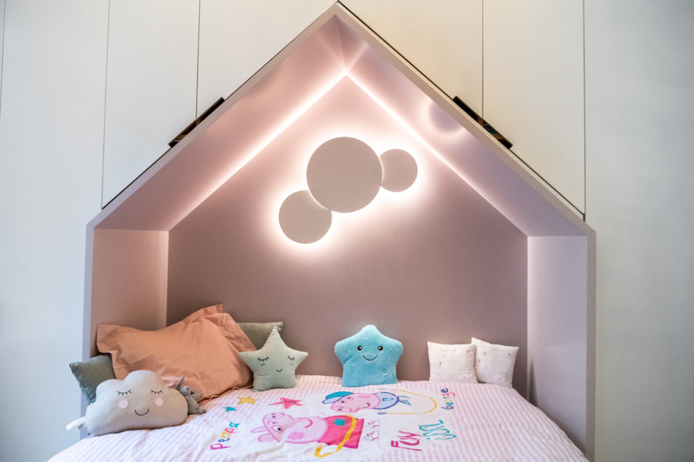 Mid-sized contemporary kids' bedroom in London with white walls, light hardwood floors and beige floor for kids 4-10 years old and girls.