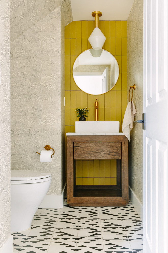 Mid-sized contemporary powder room in San Francisco with furniture-like cabinets, medium wood cabinets, yellow tile, grey walls, a vessel sink, white floor and white benchtops.