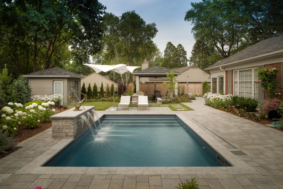 This is an example of a large contemporary backyard garden in Toronto with with waterfall and natural stone pavers.