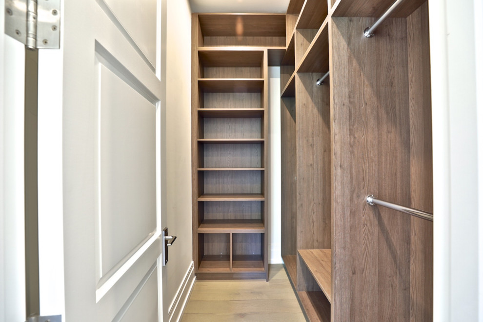 Small modern gender-neutral walk-in wardrobe in Toronto with flat-panel cabinets, light wood cabinets, ceramic floors and beige floor.