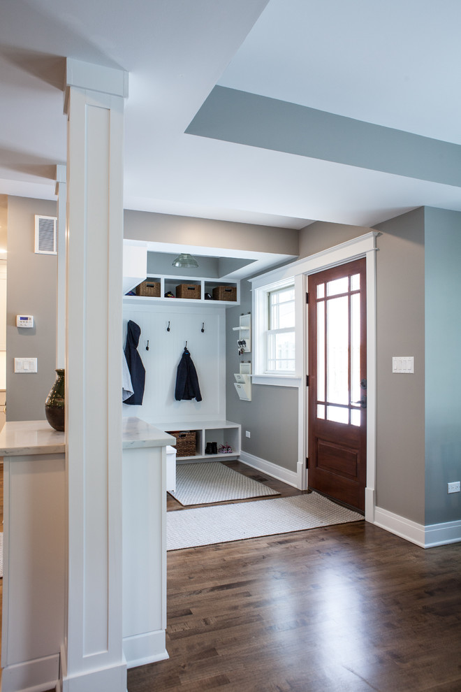 Photo of a mid-sized traditional mudroom in Chicago with grey walls, medium hardwood floors, a single front door and a medium wood front door.