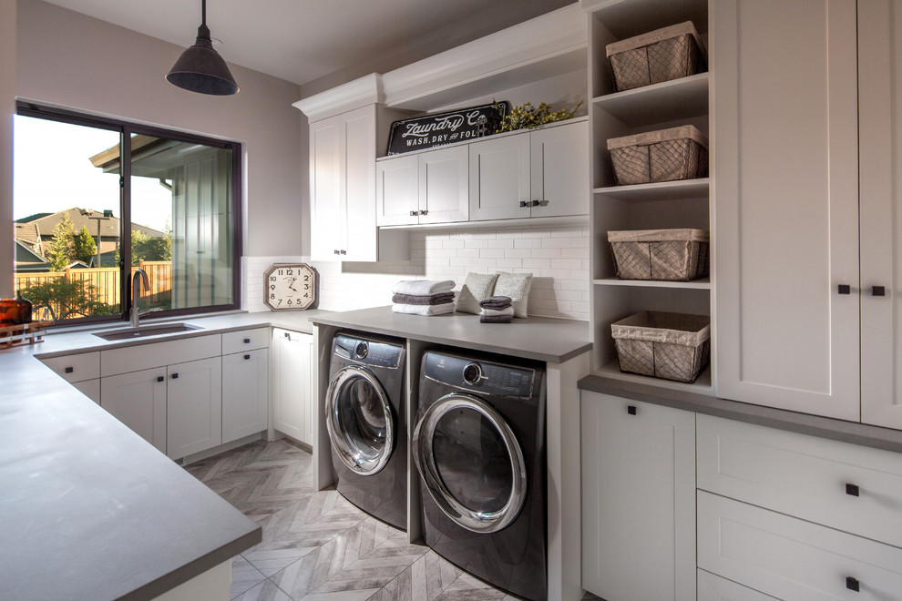Design ideas for a mid-sized country u-shaped utility room in Portland with an undermount sink, shaker cabinets, white cabinets, quartz benchtops, porcelain floors, a side-by-side washer and dryer, grey floor and grey walls.