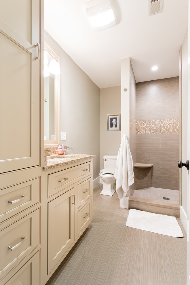 Inspiration for a mid-sized contemporary 3/4 bathroom in Boston with recessed-panel cabinets, beige cabinets, a corner shower, an undermount sink, granite benchtops, a two-piece toilet, beige tile, stone slab, vinyl floors and grey walls.