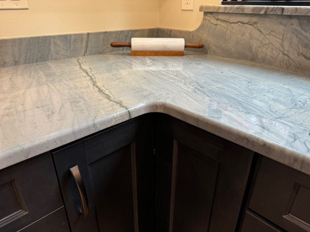 Eat-in kitchen - mid-sized transitional u-shaped laminate floor and brown floor eat-in kitchen idea in Boston with an undermount sink, shaker cabinets, brown cabinets, quartz countertops, black appliances, an island and multicolored countertops