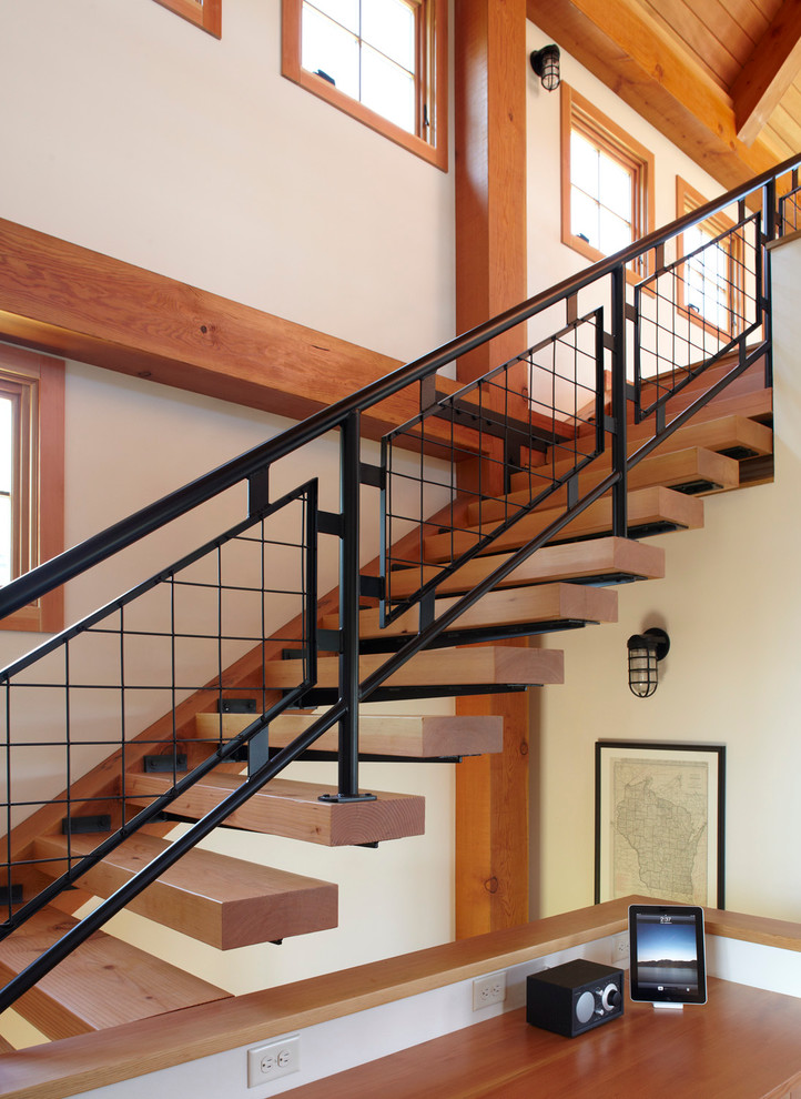 This is an example of a country floating staircase in Milwaukee with open risers and metal railing.