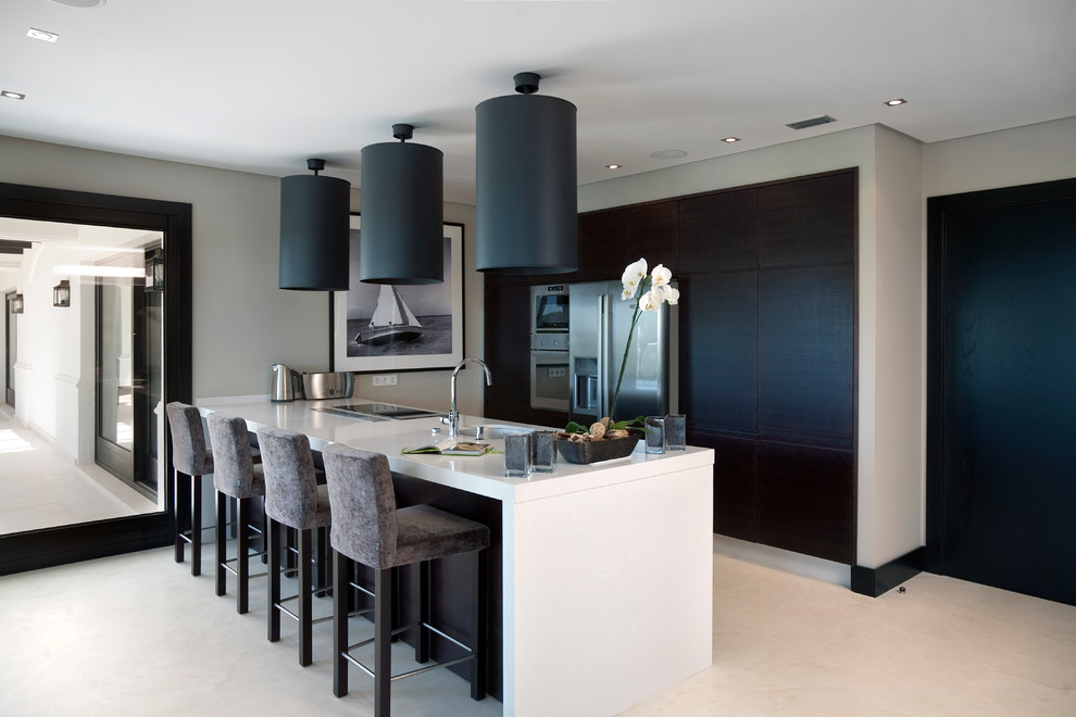 Design ideas for a contemporary kitchen in Milan with an undermount sink, flat-panel cabinets, black cabinets, stainless steel appliances, a peninsula, beige floor and white benchtop.