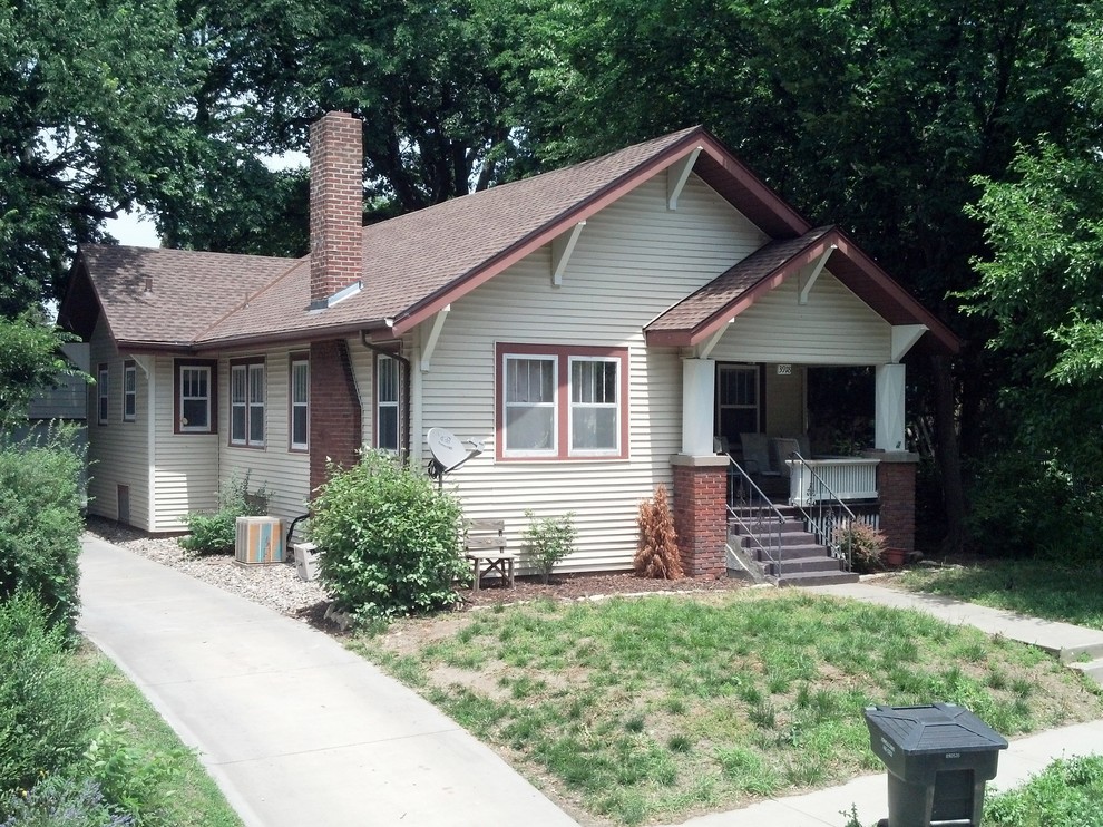 This is an example of a small traditional one-storey beige exterior in Omaha with vinyl siding and a gable roof.