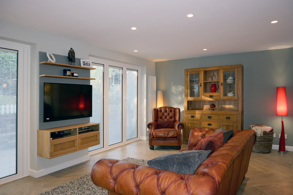 Стильный дизайн: большая изолированная гостиная комната в современном стиле с серыми стенами, полом из керамической плитки, телевизором на стене и коричневым полом - последний тренд