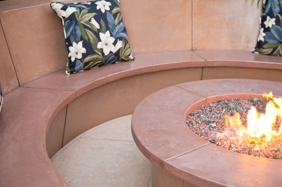Design ideas for a mid-sized tropical backyard patio in San Francisco with a fire feature, stamped concrete and no cover.