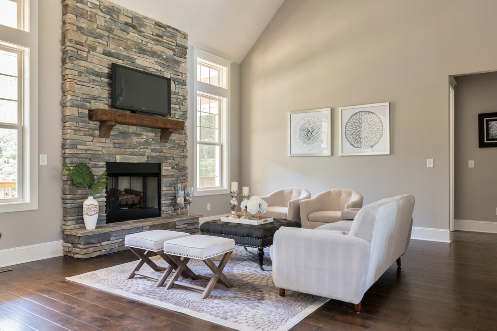 Inspiration for a mid-sized arts and crafts open concept family room in Charlotte with beige walls, dark hardwood floors, a standard fireplace, a stone fireplace surround, a wall-mounted tv and brown floor.