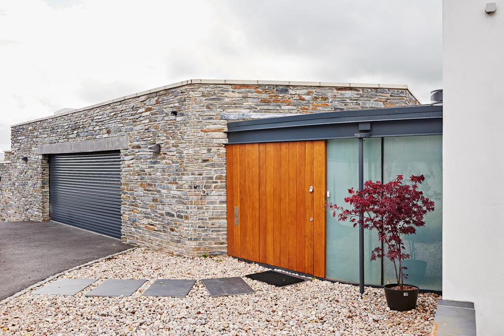 This is an example of a large contemporary attached one-car garage in Devon.