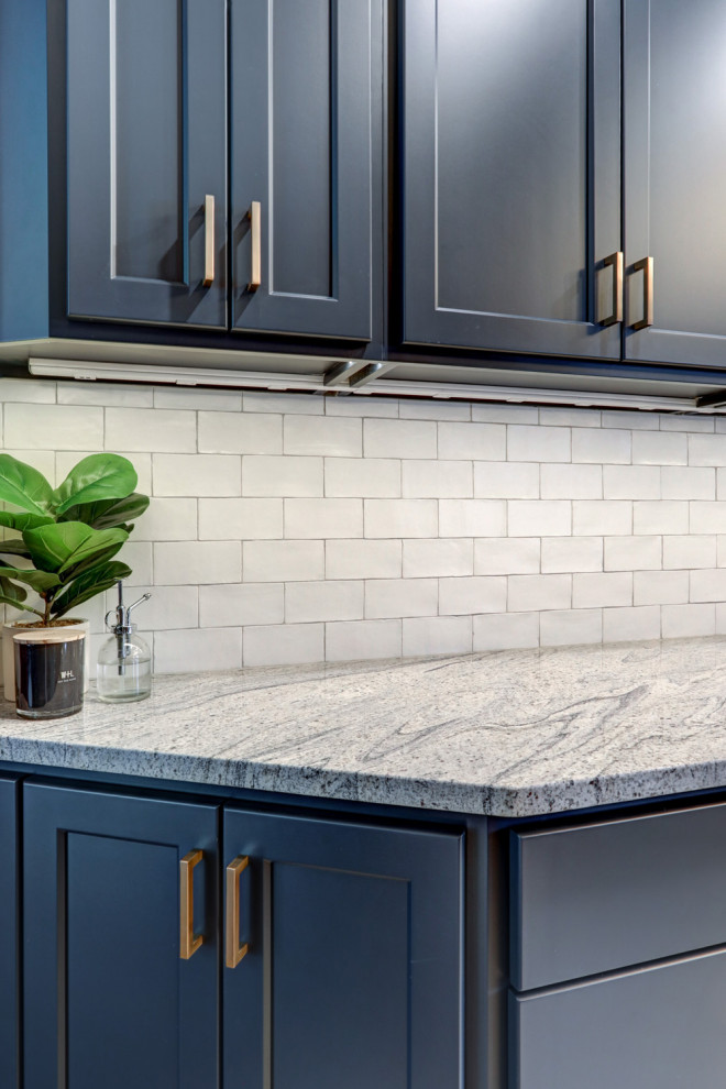 Kitchen pantry - mid-sized transitional l-shaped vinyl floor and gray floor kitchen pantry idea with a farmhouse sink, recessed-panel cabinets, blue cabinets, granite countertops, white backsplash, subway tile backsplash, stainless steel appliances, no island and gray countertops