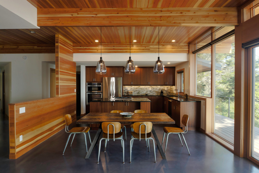 This is an example of a contemporary kitchen/dining combo in Seattle with concrete floors.
