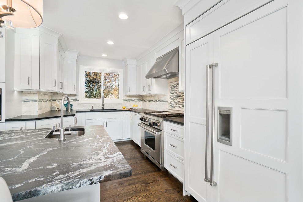 Inspiration for a huge transitional u-shaped dark wood floor and brown floor eat-in kitchen remodel in Providence with an undermount sink, recessed-panel cabinets, white cabinets, granite countertops, white backsplash, marble backsplash, stainless steel appliances and an island