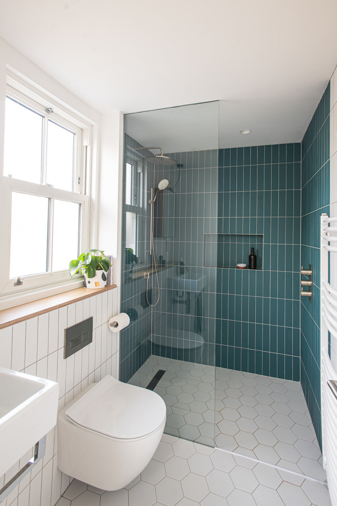 Minimalistisk inredning av ett mellanstort badrum med dusch, med våtrum, en vägghängd toalettstol, flerfärgad kakel, keramikplattor, flerfärgade väggar, klinkergolv i keramik, ett väggmonterat handfat, träbänkskiva, vitt golv och med dusch som är öppen