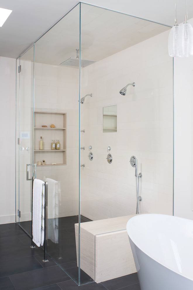 Inspiration for a mid-sized modern master bathroom in Los Angeles with flat-panel cabinets, medium wood cabinets, a freestanding tub, a curbless shower, beige tile, ceramic tile, white walls, ceramic floors, a drop-in sink, limestone benchtops, grey floor, a hinged shower door and beige benchtops.